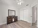 Bedroom features closet, wood-look flooring, and dark wood dresser with a mirror at 1491 Nappa Dr, Port Orange, FL 32128