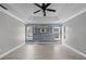 Bright bedroom featuring a decorative accent wall, tray ceiling, and light wood flooring at 1491 Nappa Dr, Port Orange, FL 32128