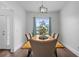 Dining room with a wooden table, upholstered chairs, and a view of the front yard at 1491 Nappa Dr, Port Orange, FL 32128