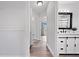 Hallway view with wood-look floors leading to bathroom, showcasing neutral tones and natural light at 1491 Nappa Dr, Port Orange, FL 32128
