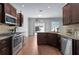 Charming kitchen featuring stainless steel appliances, granite countertops, dark wood cabinets, and wood-look tile flooring at 1491 Nappa Dr, Port Orange, FL 32128
