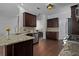 Lovely kitchen featuring dark wood cabinets, granite countertops, stainless appliances and wood-look flooring at 1491 Nappa Dr, Port Orange, FL 32128