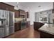 Well-designed kitchen with stainless steel appliances, granite countertops, dark wood cabinets, and wood-look flooring at 1491 Nappa Dr, Port Orange, FL 32128