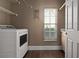 Functional laundry room featuring washer, dryer, shelving, window, and tile flooring at 1491 Nappa Dr, Port Orange, FL 32128
