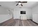 Bright, open living room featuring wood-look flooring, a ceiling fan, and a modern entertainment center at 1491 Nappa Dr, Port Orange, FL 32128