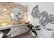 Stylish bathroom with a round mirror, pendent lighting, stone accent wall, and unique storage shelf for towels at 160 Point O Woods Dr, Daytona Beach, FL 32114