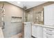 Beautiful bathroom featuring walk-in shower with tiled walls, niche, and vanity with double mirrors at 160 Point O Woods Dr, Daytona Beach, FL 32114