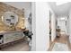 Charming bathroom featuring stone accent wall, round mirror, and open entryway with hallway nearby at 160 Point O Woods Dr, Daytona Beach, FL 32114