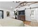 Bright bedroom features wood floors, shiplap walls, barn door access to the bathroom at 160 Point O Woods Dr, Daytona Beach, FL 32114