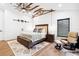 Vaulted ceiling bedroom with beams, ceiling fan, platform bed and sitting area at 160 Point O Woods Dr, Daytona Beach, FL 32114