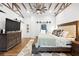 Bright bedroom with wood ceiling beams, wood floors, shiplap accent wall, and closet at 160 Point O Woods Dr, Daytona Beach, FL 32114