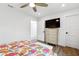 Bedroom with hardwood flooring, dresser, television, ceiling fan, open doorway, and stylish decor at 160 Point O Woods Dr, Daytona Beach, FL 32114