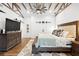 Primary bedroom features a ceiling fan, wooden beams, wood floors, and ample natural light at 160 Point O Woods Dr, Daytona Beach, FL 32114