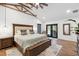 Bright bedroom featuring hardwood floors, wooden ceiling beams, and patio access at 160 Point O Woods Dr, Daytona Beach, FL 32114