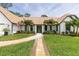 Inviting home featuring a lush lawn, walkway, manicured landscaping, and elegant exterior finishes at 160 Point O Woods Dr, Daytona Beach, FL 32114