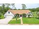 Charming brick home featuring manicured lawn, symmetrical landscaping, and attached two car garage at 160 Point O Woods Dr, Daytona Beach, FL 32114