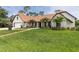 Beautiful home featuring a spacious lawn, manicured landscaping, and elegant exterior finishes at 160 Point O Woods Dr, Daytona Beach, FL 32114