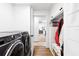 Bright laundry room with washer, dryer, white cabinets, and a bench with storage space at 160 Point O Woods Dr, Daytona Beach, FL 32114