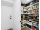 Walk-in pantry featuring white shelves with storage for drinks, food, cooking supplies, and cleaning supplies at 160 Point O Woods Dr, Daytona Beach, FL 32114
