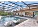 Backyard pool featuring a hot tub, sun loungers, and outdoor dining area with a barbecue, perfect for entertaining at 160 Point O Woods Dr, Daytona Beach, FL 32114