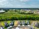 Wide aerial shot of a new development featuring multiple homes, green spaces, and distant water views at 16241 Honey Harvest St, Winter Garden, FL 34787