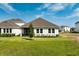 Well-maintained backyard featuring a lush lawn, mature landscaping, and a view of the house at 16241 Honey Harvest St, Winter Garden, FL 34787