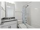 Bathroom features shower and tub combination with blue and white shower curtain, toilet, and gray vanity at 16241 Honey Harvest St, Winter Garden, FL 34787