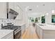 Modern kitchen with stainless steel appliances, an island with bar seating, and a clear view into the dining area at 16241 Honey Harvest St, Winter Garden, FL 34787