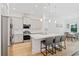 Contemporary kitchen featuring an island with bar stools, stainless steel appliances, and pendant lighting at 16241 Honey Harvest St, Winter Garden, FL 34787