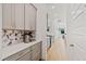 Long, narrow gourmet kitchen with grey cabinets, stainless appliances, quartz countertops, and decorative backsplash at 16241 Honey Harvest St, Winter Garden, FL 34787