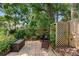 Private backyard brick patio area with outdoor seating and a gas grill, surrounded by mature trees and landscaping at 1637 Bent Oaks Blvd, Deland, FL 32724