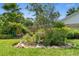 Backyard landscape featuring a bird bath surrounded by lush greenery, rocks, and vibrant flowers, enhancing the outdoor ambiance at 1637 Bent Oaks Blvd, Deland, FL 32724