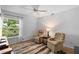 A bedroom has two chairs, an end table, and a large window at 1637 Bent Oaks Blvd, Deland, FL 32724
