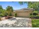 Attractive home exterior with a two-car garage, brick accents, and nicely landscaped front yard with mature trees at 1637 Bent Oaks Blvd, Deland, FL 32724