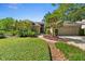 Charming single-story home with beautiful landscaping, green lawn, and a brick walkway leading to the front door at 1637 Bent Oaks Blvd, Deland, FL 32724