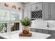 Close-up of a kitchen featuring gray cabinets, a wine rack, and a decorative still-life on the quartz countertop at 1637 Bent Oaks Blvd, Deland, FL 32724