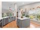 Bright, modern kitchen with gray cabinets, stainless steel appliances, island, and farm sink at 1637 Bent Oaks Blvd, Deland, FL 32724