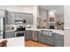 Modern kitchen with gray cabinets, stainless steel appliances, and a farm sink at 1637 Bent Oaks Blvd, Deland, FL 32724