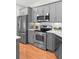Kitchen showcasing stainless steel appliances, granite countertops and grey cabinetry at 1637 Bent Oaks Blvd, Deland, FL 32724