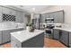 Modern kitchen with gray cabinets, stainless steel appliances, and a central island with white countertop at 1637 Bent Oaks Blvd, Deland, FL 32724