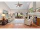 Sun-filled living room with a fireplace, ceiling fan, and sliding glass doors leading to a screened patio at 1637 Bent Oaks Blvd, Deland, FL 32724