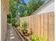 Side yard featuring a stone walkway, new wooden fence, and lush landscaping with potted plants at 1637 Bent Oaks Blvd, Deland, FL 32724