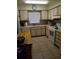 This kitchen features tiled floors, wooden cabinets, a white oven, and a stainless steel sink at 1640 Juno Trl # 103F, Astor, FL 32102