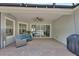 Covered back patio featuring brick pavers, ceiling fan, and comfortable seating area at 171 Birchmont Dr, Deland, FL 32724