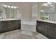This bathroom features dual vanities, a soaking tub, and neutral tiling at 171 Birchmont Dr, Deland, FL 32724