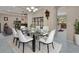 Bright dining room featuring a glass table, white chairs, chandelier and an open floor plan at 171 Birchmont Dr, Deland, FL 32724