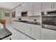 Updated kitchen featuring white cabinets, dark countertops, stainless steel appliances, and tile backsplash at 171 Birchmont Dr, Deland, FL 32724