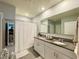 Bathroom with double sink vanity, granite countertops, a framed mirror, and a shower/tub combo with neutral paint at 1759 Copinger Ter, Kissimmee, FL 34744