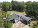 Aerial view of a single-story home with a dark roof, chimney and a yard with mature trees at 1880 N Sparkman Ave, Orange City, FL 32763