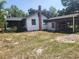 Rear exterior of the home featuring a brick chimney and carport at 1880 N Sparkman Ave, Orange City, FL 32763